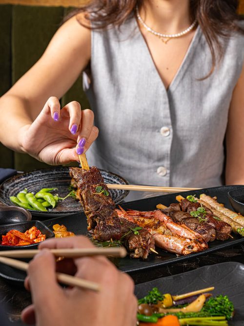 Woman eating asian inspired skewers